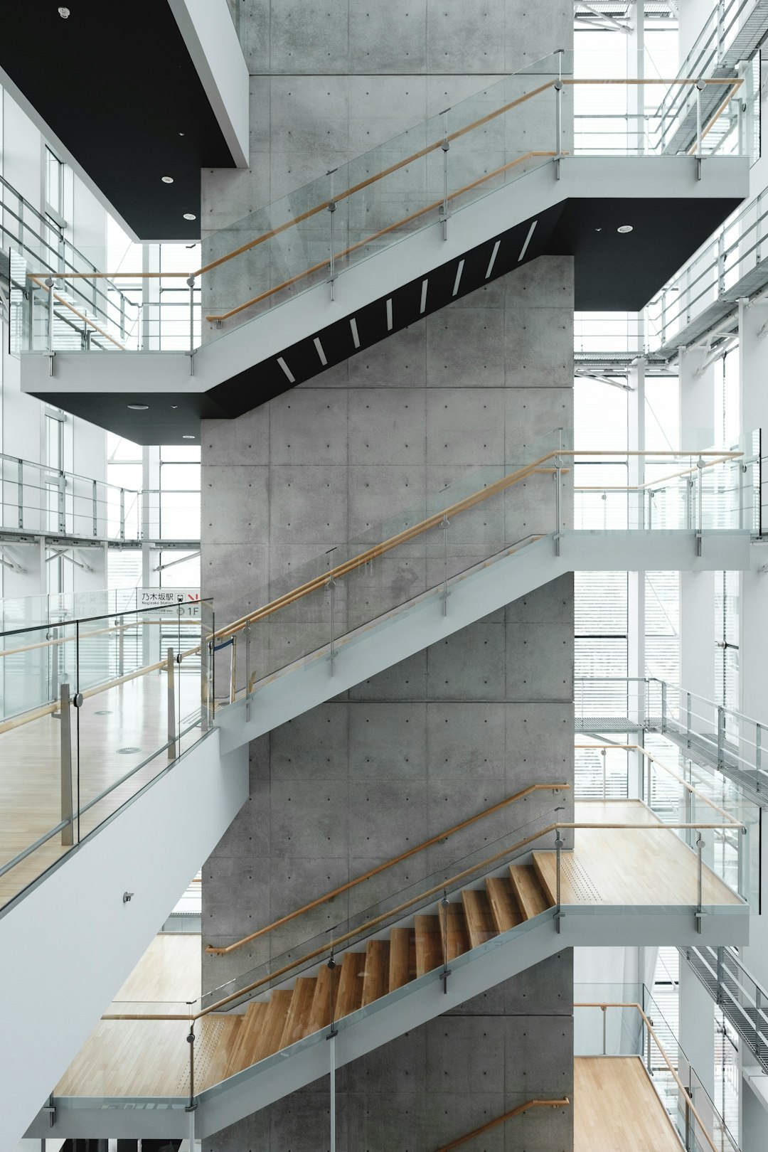 Light-filled contemporary interior with glass balustrades and rising staircases